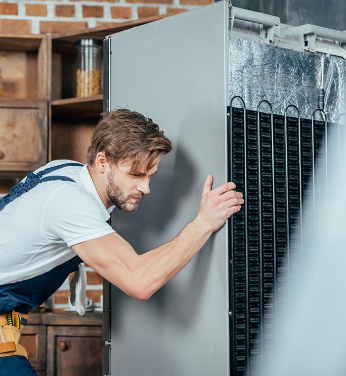 young-repairman-in-protective-workwear-moving-refr-resize.jpg